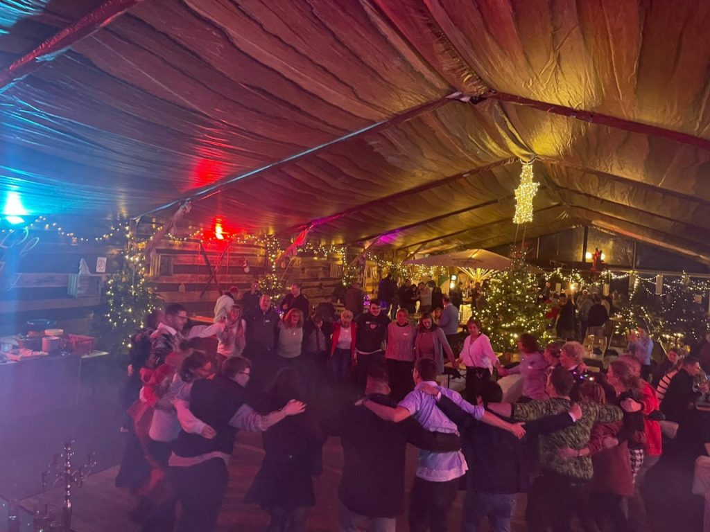 Partygäste tanzen in einem festlich geschmückten Zelt