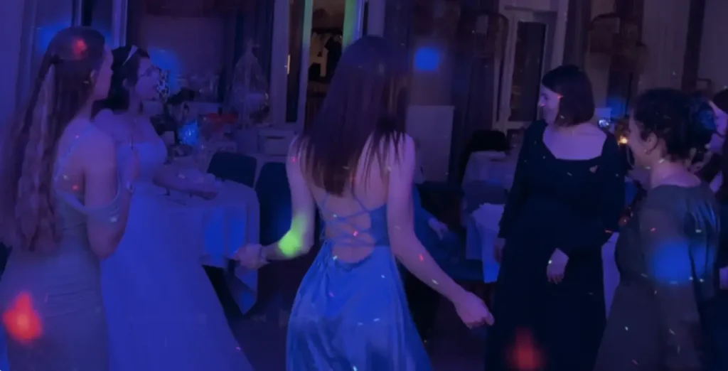 Frauen in Abendkleidern und Brautkleid tanzen auf einer Party