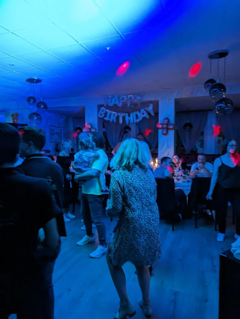 Frauen in Abendkleidern und Brautkleid tanzen auf einer Party