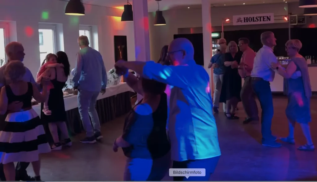 Frauen in Abendkleidern und Brautkleid tanzen auf einer Party